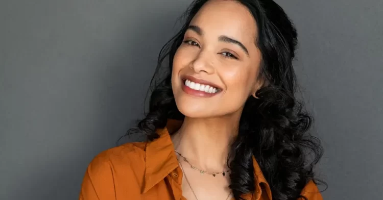 Woman with dark hair smiling showing off her bright, white teeth.