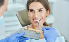 A patient smiling while dentist checks colour match.