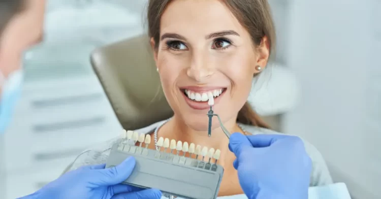 A patient smiling while dentist checks colour match.